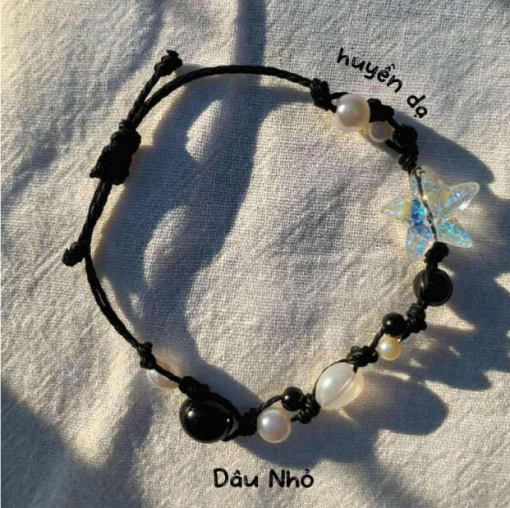 "Huyền Dạ" Màu sắc: Dây đen kết hợp hạt đá đen, ngọc trai trắng và pha lê ánh xanh. Điểm nhấn: Hạt hình ngôi sao ánh xanh hologram nổi bật. Phong cách: Bí ẩn, cá tính, phù hợp với phong cách mạnh mẽ và độc lập.